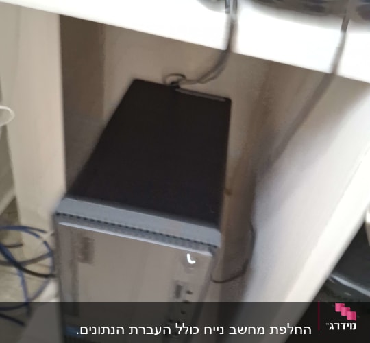 מחשב שולחני עם כבלים בסביבה משרדית
